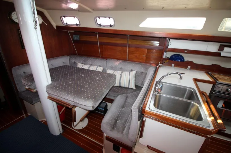 Slide: The Image of Interior of 1987 Catalina 34 sailboat with cozy seating and compact kitchen area. - 15