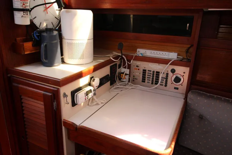 Slide: The Image of Navigation station inside 1987 Catalina 34 sailboat with control panel and equipment. - 17