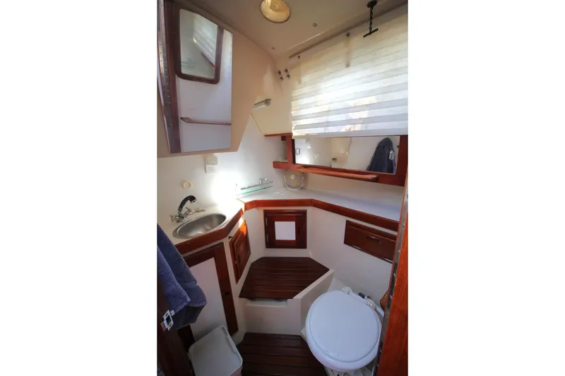 Slide: The Image of 1987 Catalina 34 yacht bathroom with wooden accents, sink, and toilet. - 20