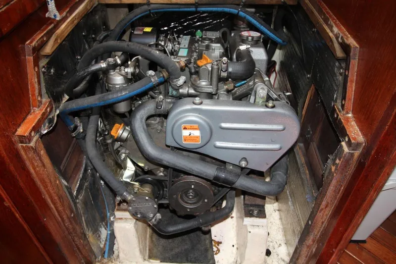 Slide: The Image of Engine compartment of a 1987 Catalina 34 sailboat, featuring hoses and mechanical components. - 22
