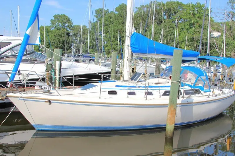 Slide: The Image of 1987 Catalina 34 sailboat docked in a marina with blue covers and clear skies. - 6