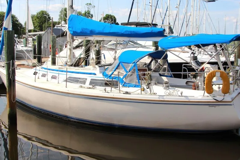 Slide: The Image of 1987 Catalina 34 sailboat docked with blue covers and lifebuoy. - 7