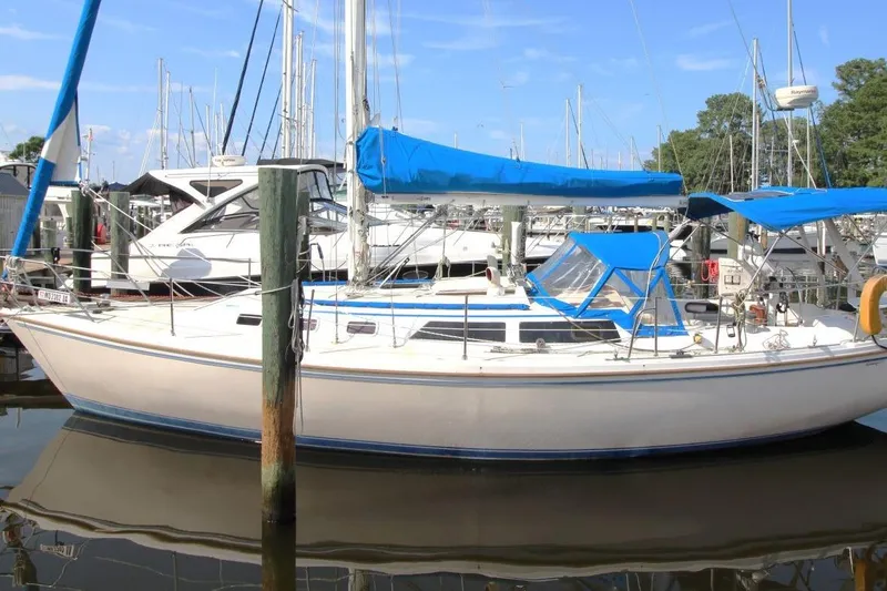 Slide: The Image of 1987 Catalina 34 sailboat docked in marina with blue covers and clear sky. - 8
