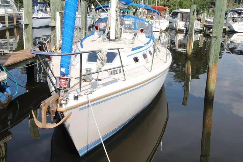 Slide: The Image of 1987 Catalina 34 sailboat docked in a marina, featuring a blue sail cover. - 9