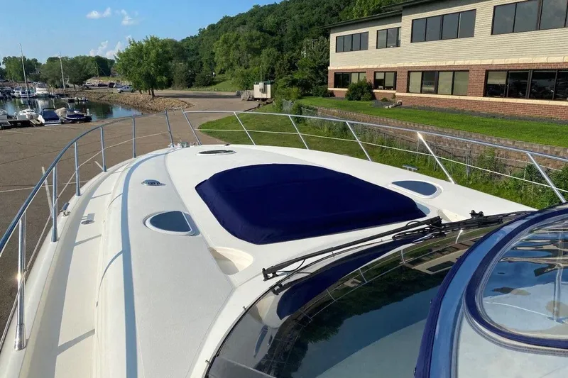 Slide: The Image of 1998 Sunseeker Predator 58 yacht docked near a marina with lush greenery. - 11