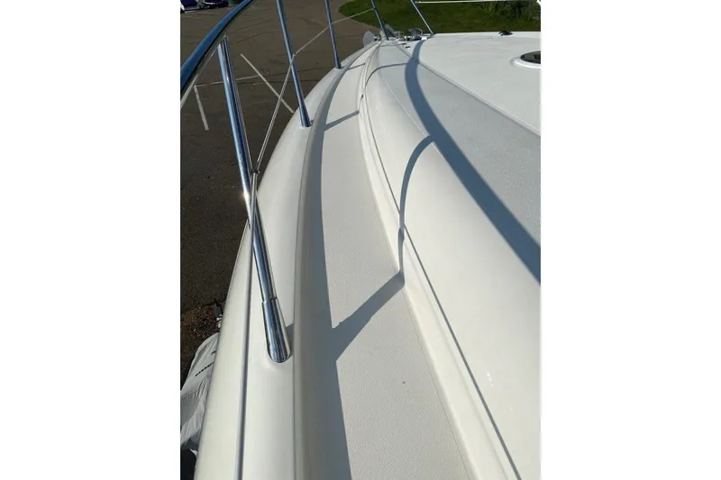 Slide: The Image of 1998 Sunseeker Predator 58 yacht deck with sleek white surface and metal railings. - 14