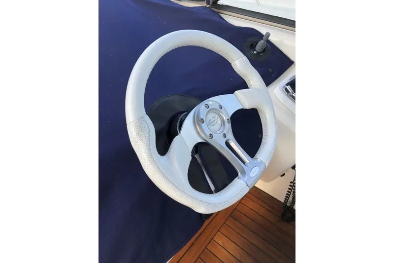 Slide: The Image of Steering wheel of a 1998 Sunseeker Predator 58 yacht, featuring a sleek design. - 16
