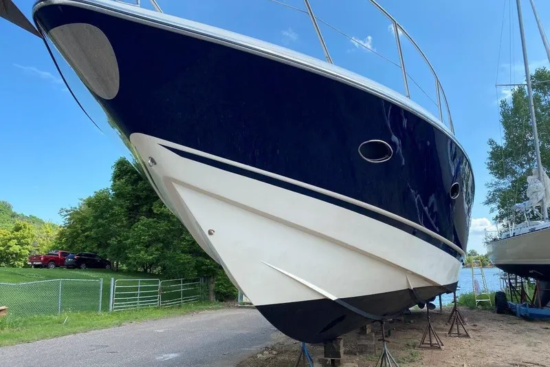 Slide: The Image of 1998 Sunseeker Predator 58 yacht on land, blue and white hull, clear sky background. - 2