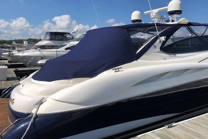 Slide: The Image of 1998 Sunseeker Predator 58 yacht docked, featuring sleek design and blue cover. - 3