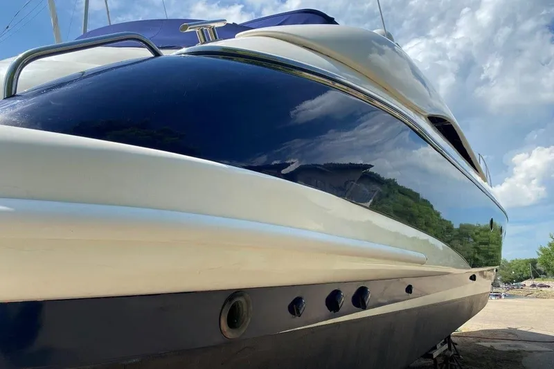 Slide: The Image of 1998 Sunseeker Predator 58 yacht with sleek design under a blue sky. - 4