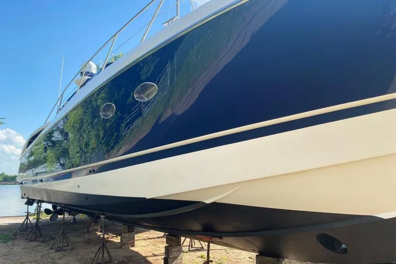 Slide: The Image of 1998 Sunseeker Predator 58 yacht on stands, glossy blue hull, sunny day. - 5