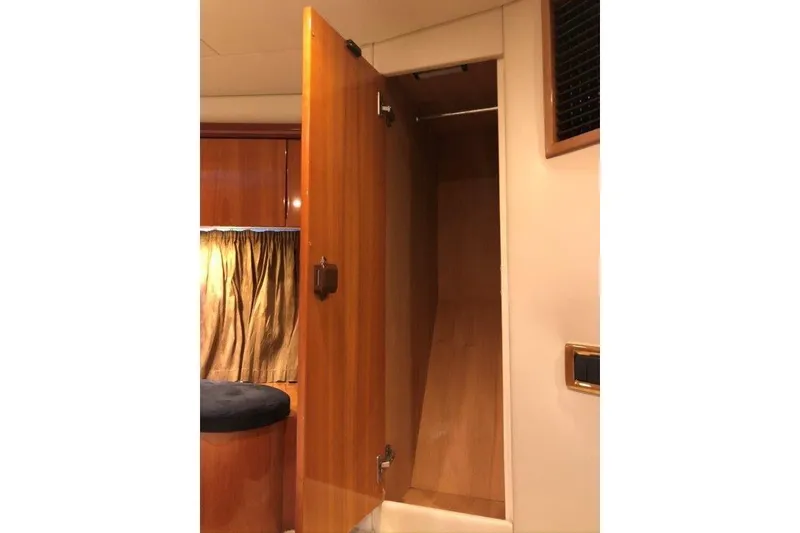 Slide: The Image of Interior view of a 1998 Sunseeker Predator 58 yacht, featuring a wooden closet. - 51