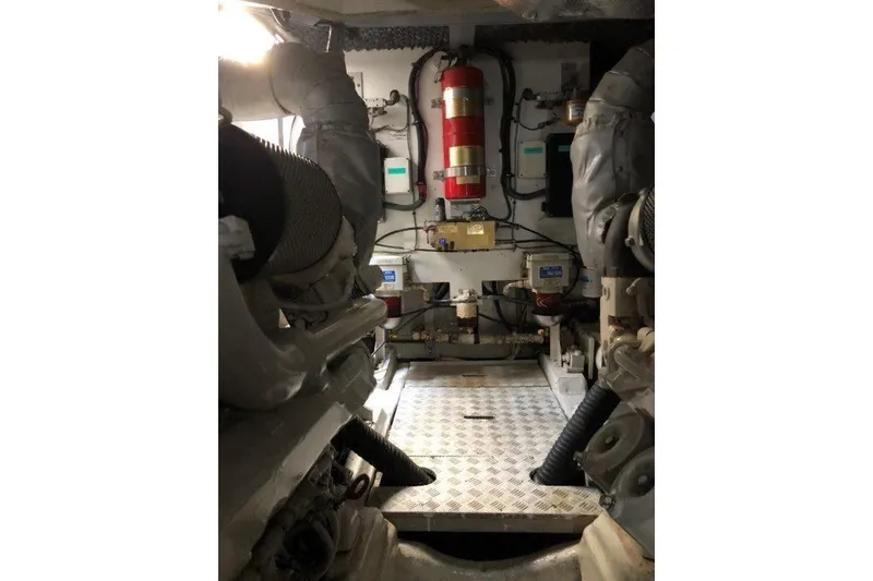 Slide: The Image of Engine room of 1998 Sunseeker Predator 58 yacht, featuring mechanical components and fire extinguisher. - 60