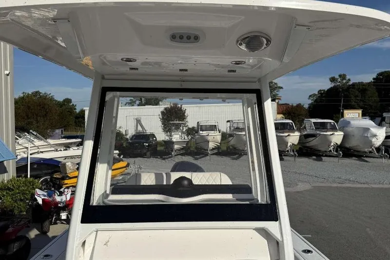 Slide: The Image of 2026 Sea Fox 248 Commander boat console with windshield, parked among other boats. - 15