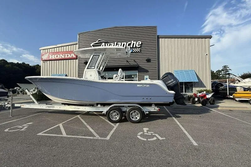 Slide: The Image of 2026 Sea Fox 248 Commander boat on trailer outside dealership, clear sky background. - 2
