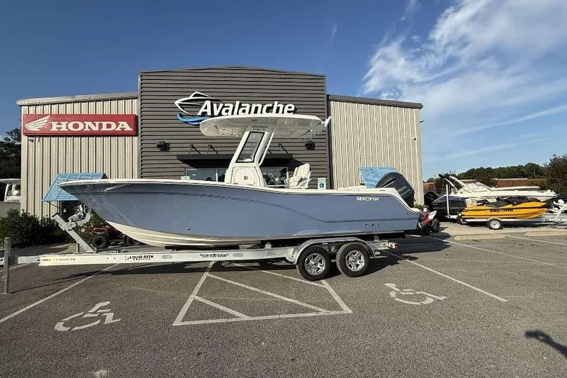 Slide: The Image of 2026 Sea Fox 248 Commander boat on trailer outside dealership, sunny day. - 8