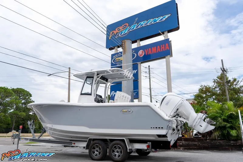 Slide: The Image of 2026 Sea Hunt Gamefish 25 boat on trailer at dealership, featuring Yamaha engines. - 1