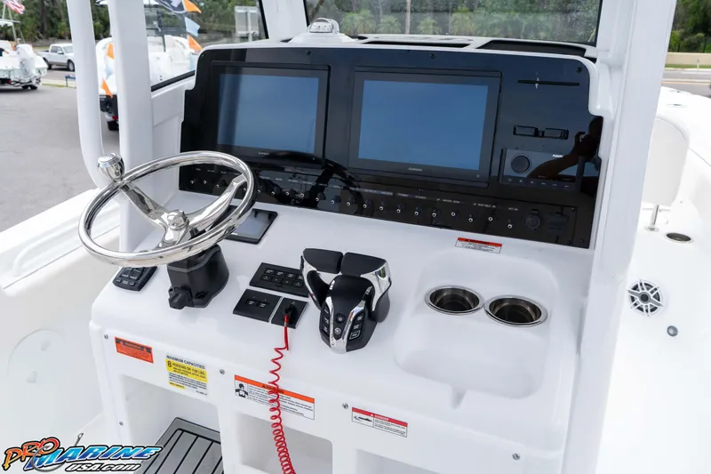 Slide: The Image of 2026 Sea Hunt Gamefish 25 helm with dual screens, steering wheel, and controls. - 17