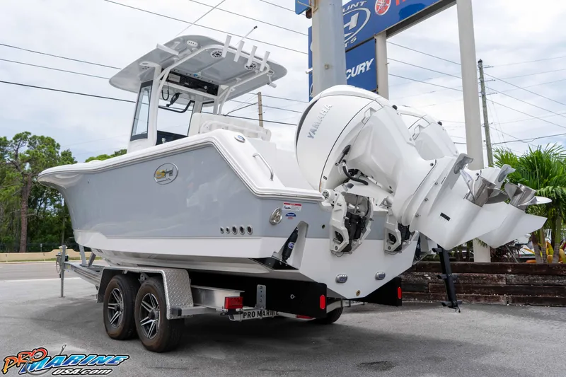Slide: The Image of 2026 Sea Hunt Gamefish 25 boat on trailer, featuring dual Yamaha outboard engines. - 2