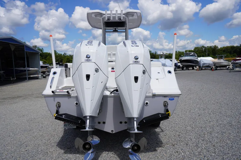 Slide: The Image of 2025 Tidewater 272 LXF boat with dual outboard engines, parked on gravel lot. - 10