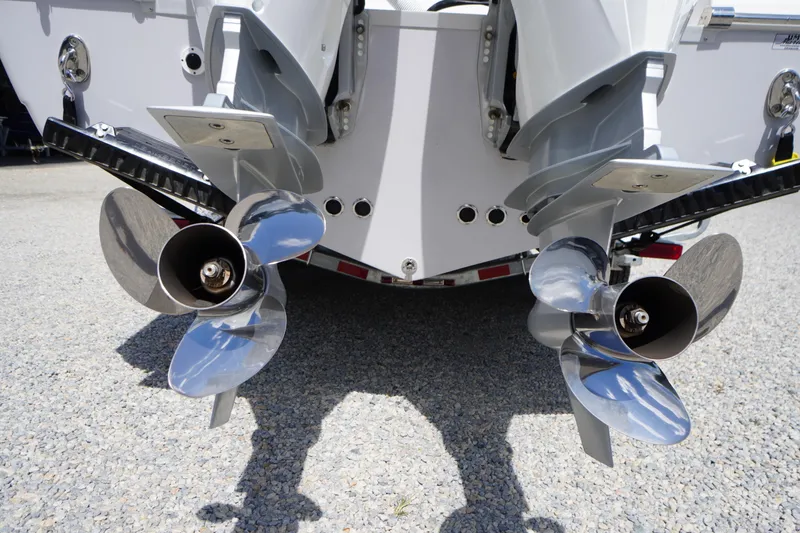Slide: The Image of 2025 Tidewater 272 LXF boat with dual outboard propellers on a gravel surface. - 11