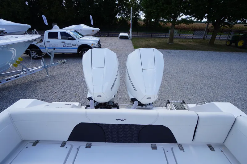 Slide: The Image of 2025 Tidewater 272 LXF boat with dual Mercury engines in a gravel lot. - 21