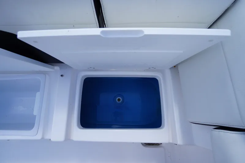 Slide: The Image of 2025 Tidewater 272 LXF boat storage compartment with open lid, showcasing interior design. - 26