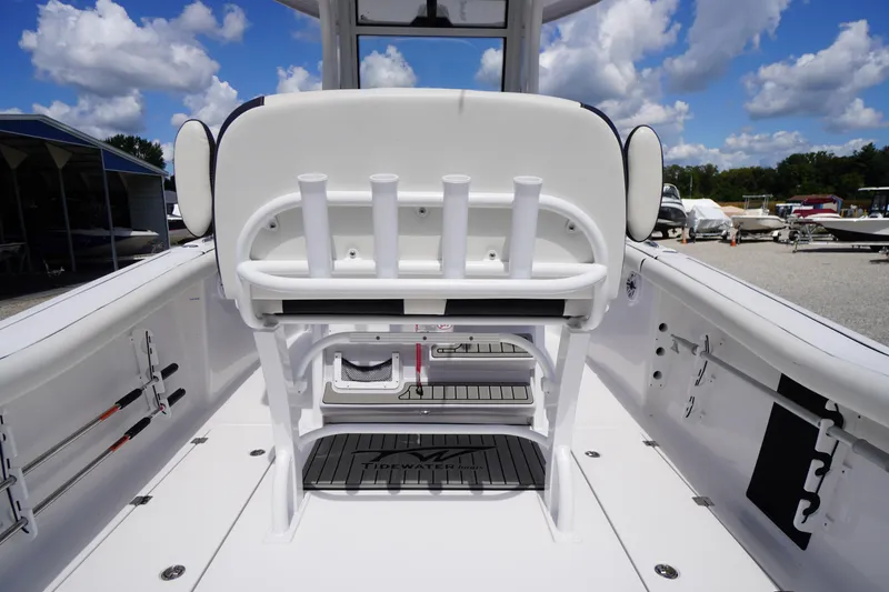 Slide: The Image of 2025 Tidewater 272 LXF boat interior with rod holders and seating, under a blue sky. - 33