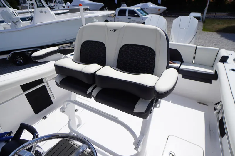 Slide: The Image of 2025 Tidewater 272 LXF boat interior with dual captain's chairs and steering wheel. - 37
