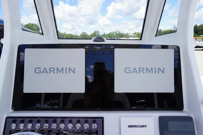 Slide: The Image of 2025 Tidewater 272 LXF boat dashboard with dual Garmin displays and Mercury controls. - 52