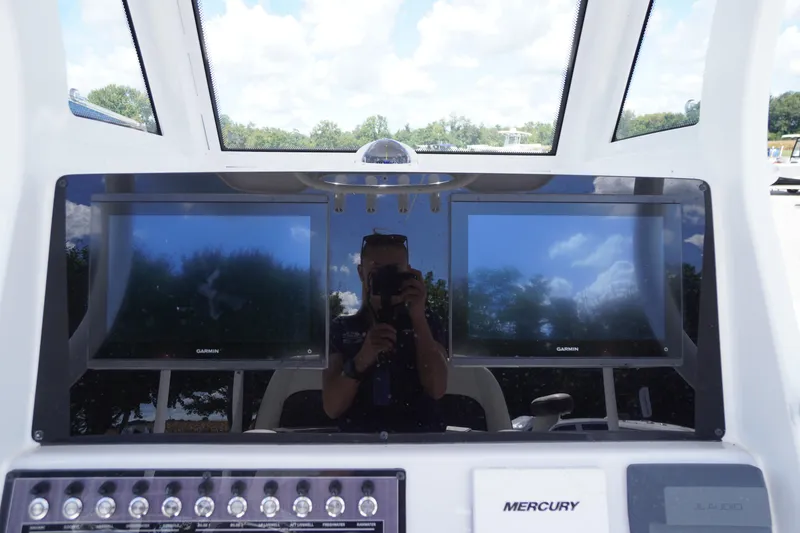 Slide: The Image of 2025 Tidewater 272 LXF boat dashboard with dual Garmin screens and Mercury controls. - 53