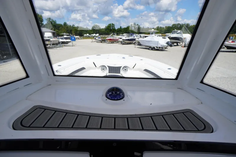 Slide: The Image of 2025 Tidewater 272 LXF boat interior view with compass, docked under blue sky. - 54