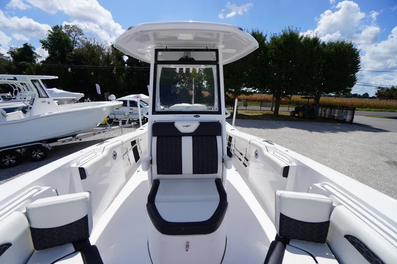 Slide: The Image of 2025 Tidewater 272 LXF boat interior with seating, under a clear blue sky. - 64