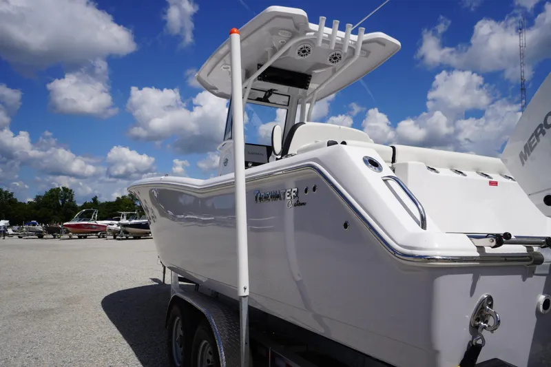 Slide: The Image of 2025 Tidewater 272 LXF boat on trailer under a bright blue sky. - 7