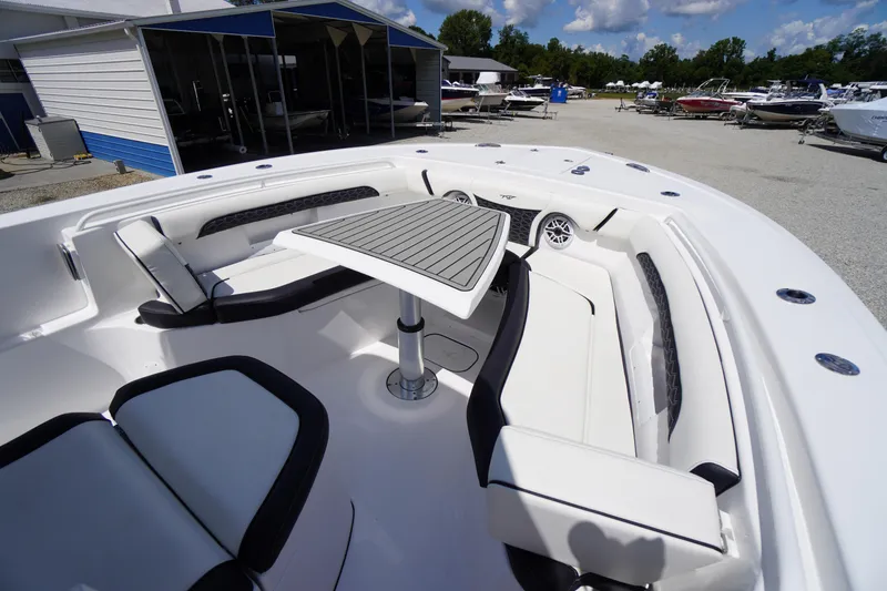 Slide: The Image of 2025 Tidewater 272 LXF boat interior with seating and table, displayed outdoors. - 73