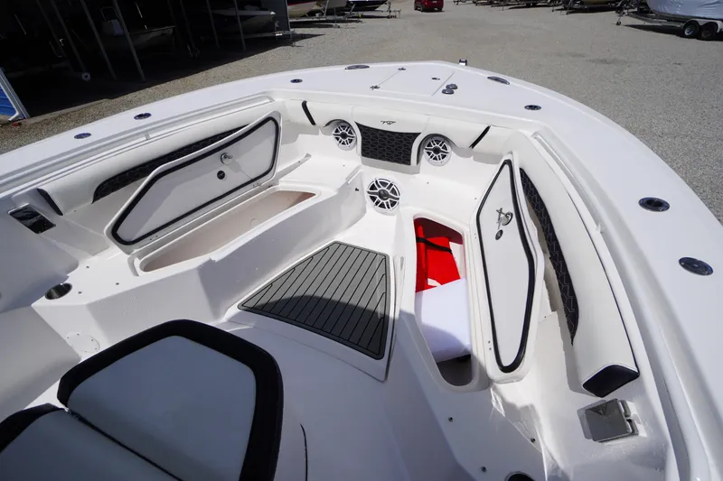 Slide: The Image of 2025 Tidewater 272 LXF boat interior with open storage compartments and speakers. - 82