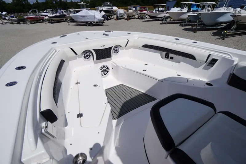 Slide: The Image of 2025 Tidewater 272 LXF boat interior with seating and speakers, displayed outdoors. - 84