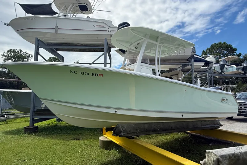 Slide: The Image of 2016 Sea Hunt Ultra 235 SE boat on a storage rack, under a partly cloudy sky. - 3