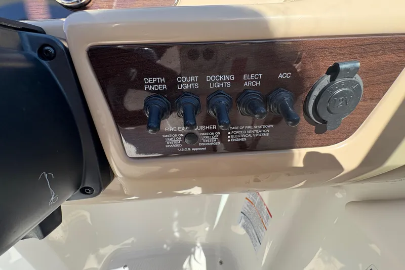 Slide: The Image of Control panel of a 2019 Chaparral 18 H2O Sport boat with switches and 12V outlet. - 10