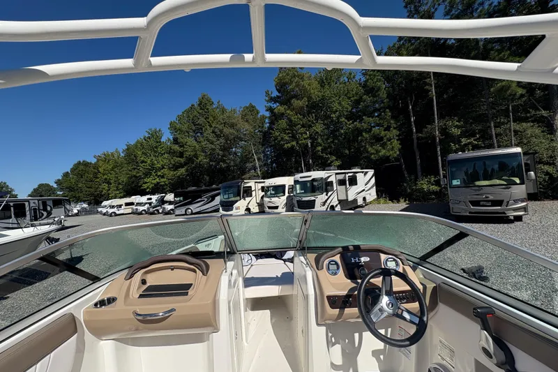 Slide: The Image of 2019 Chaparral 18 H2O Sport boat interior with RVs in the background. - 15