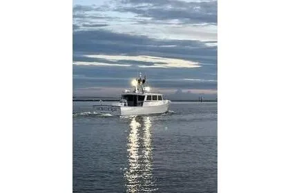 Slide: The Image of Mussle Ridge 46 boat cruising at sunset, reflecting on calm water, 2018 model. - 2