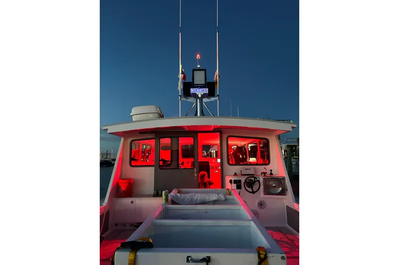 Slide: The Image of 2018 Mussle Ridge 46 boat with illuminated cabin at dusk. - 4