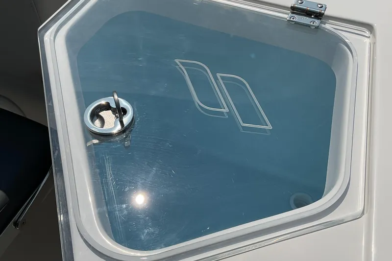 Slide: The Image of 2026 Starcraft SVX 231 OB CC boat hatch with logo and latch in sunlight. - 11