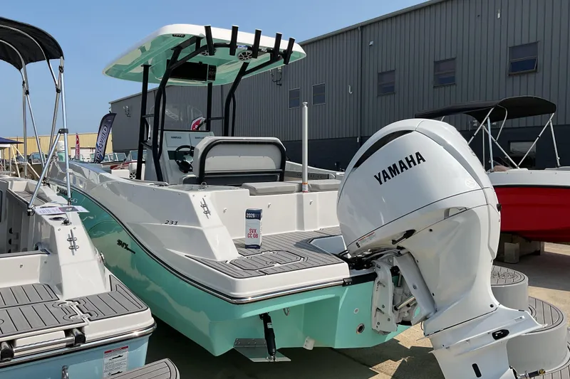 Slide: The Image of 2026 Starcraft SVX 231 OB CC boat with Yamaha engine, displayed outdoors. - 2