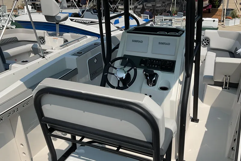 Slide: The Image of 2026 Starcraft SVX 231 OB CC boat interior with steering console and seating. - 3
