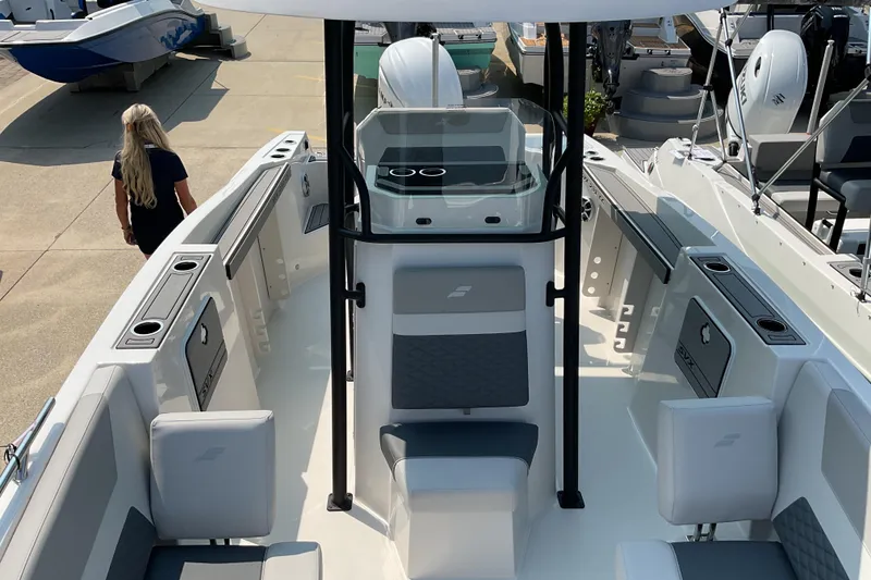Slide: The Image of 2026 Starcraft SVX 231 OB CC boat interior with seating and console, docked outdoors. - 8