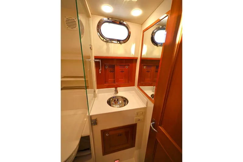 Slide: The Image of Luxurious bathroom in 2014 Hunt Yachts 44, featuring wood accents and a porthole window. - 32