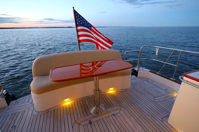 Slide: The Image of Luxurious 2014 Hunt Yachts 44 with American flag, sunset view, and elegant deck seating. - 10