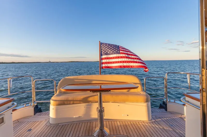 Slide: The Image of 2014 Hunt Yachts 44 with American flag, ocean view, and sunset lighting. - 9