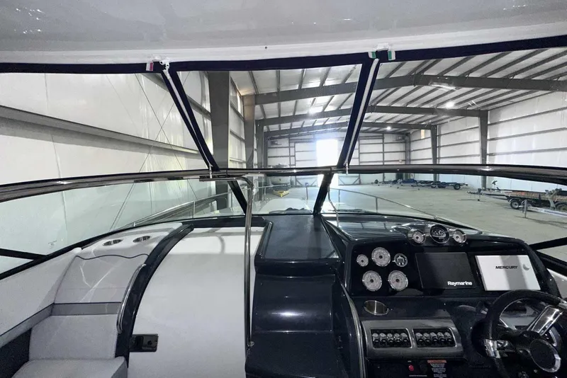 Slide: The Image of 2022 Formula 350 Sun Sport boat interior with modern dashboard and controls in a spacious warehouse. - 28